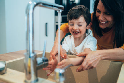 Mother and son have fun washing their hands